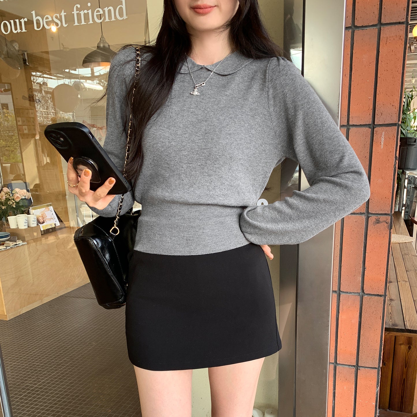 Woman wearing Peter Pan Collar Waist-Cinching Bodysuit in a stylish setting