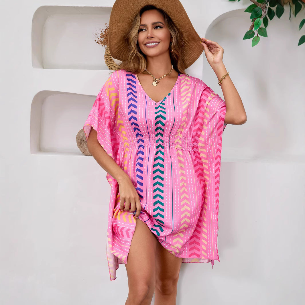 Woman wearing Bohemian Floral V-Neck Mini Dress in a sunny beach setting