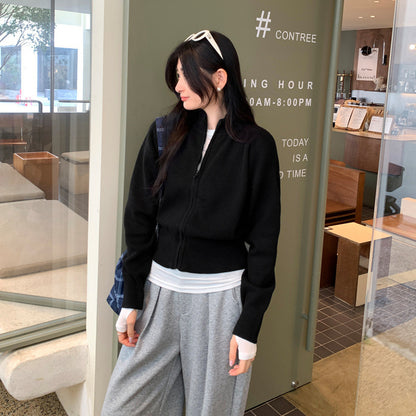 Woman wearing zippered long sleeve knit cardigan coat in urban setting