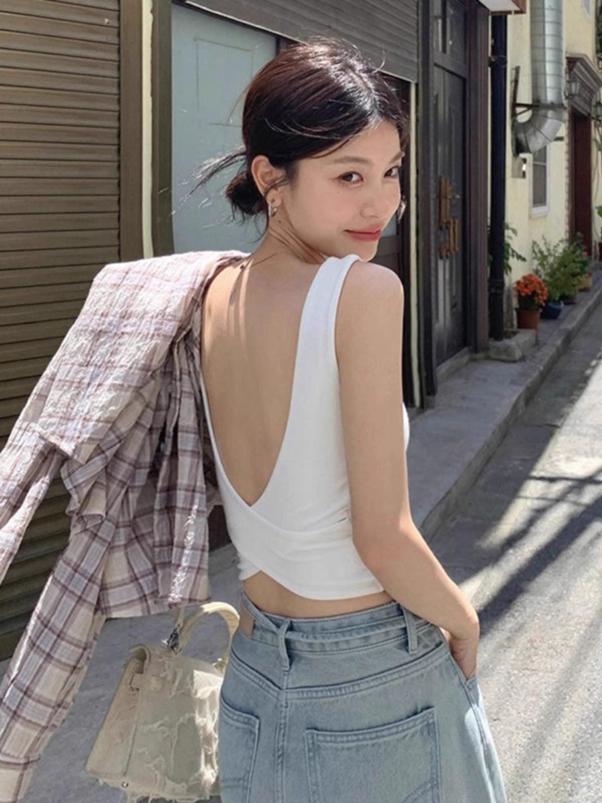 Woman wearing Cross Backless Camisole in a sunny outdoor setting