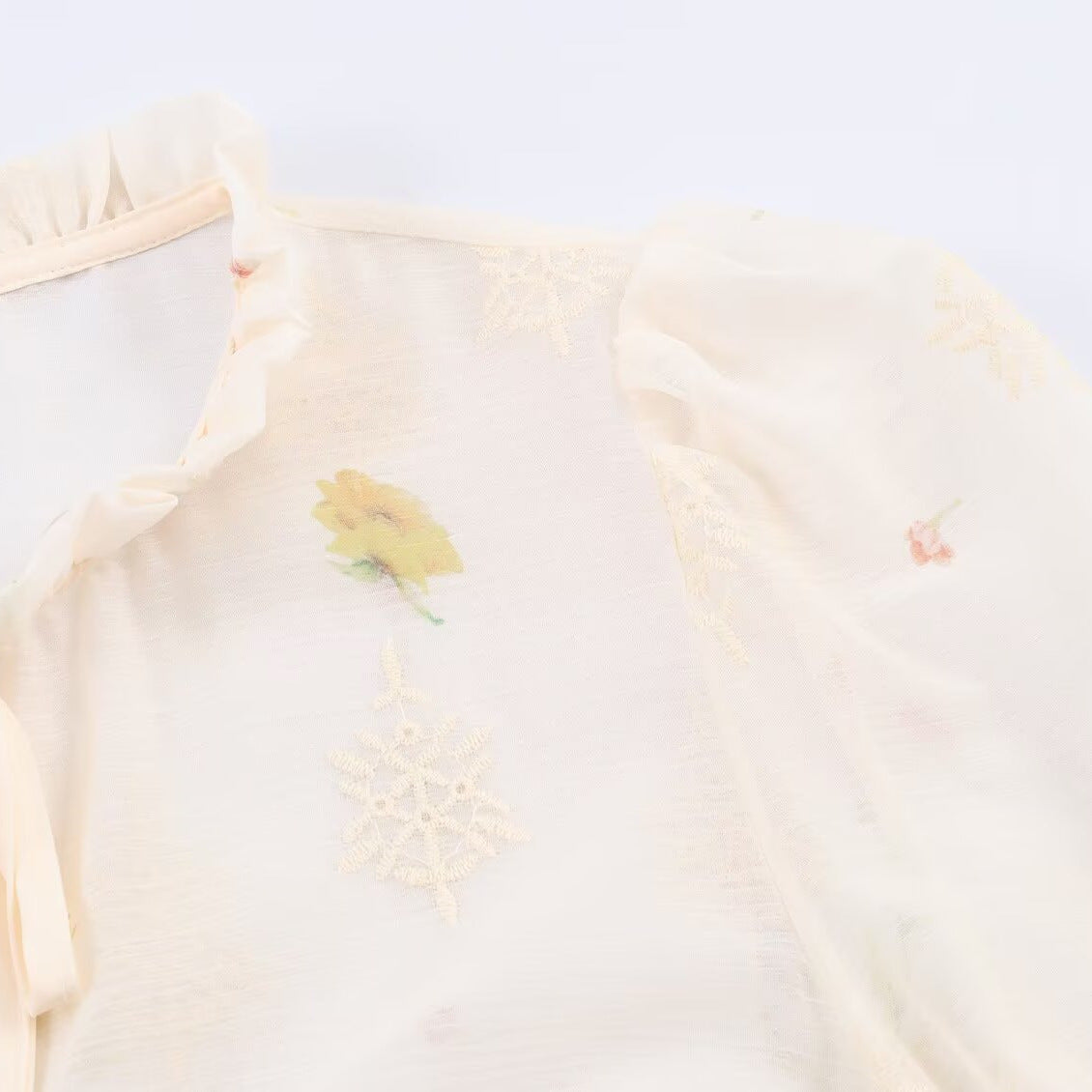 Woman wearing Embroidered Lantern Sleeve Shirt with Lace-Up Tie in a stylish setting