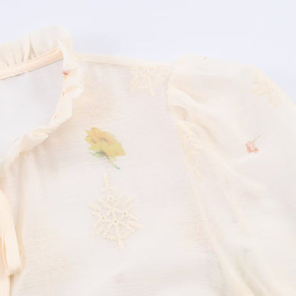 Woman wearing Embroidered Lantern Sleeve Shirt with Lace-Up Tie in a stylish setting