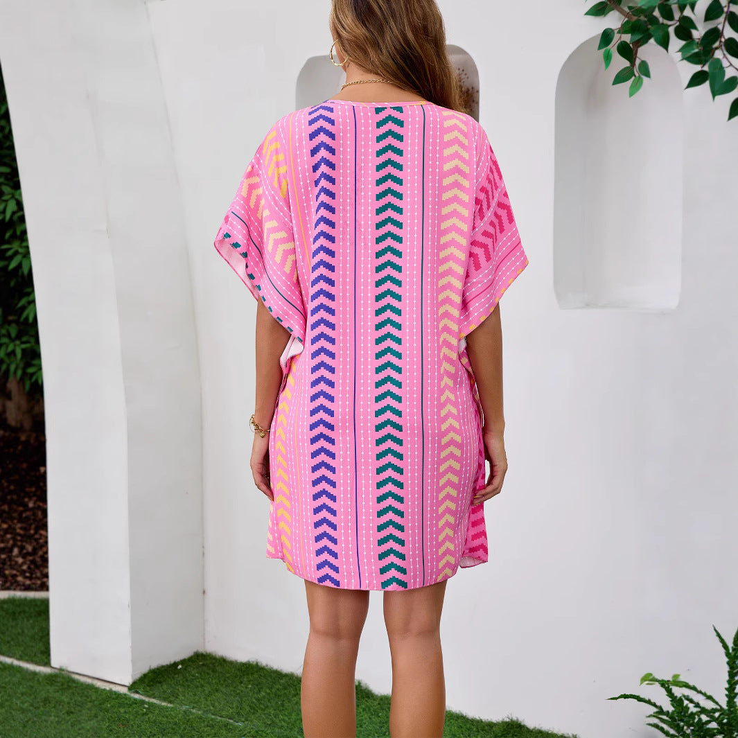 Woman wearing Bohemian Floral V-Neck Mini Dress in a sunny beach setting