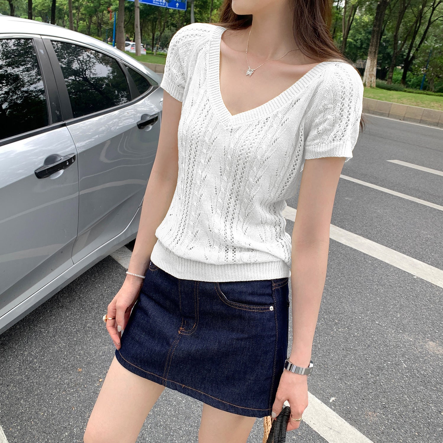 Woman wearing V-Neck Hollow Knit Top in a stylish outdoor setting
