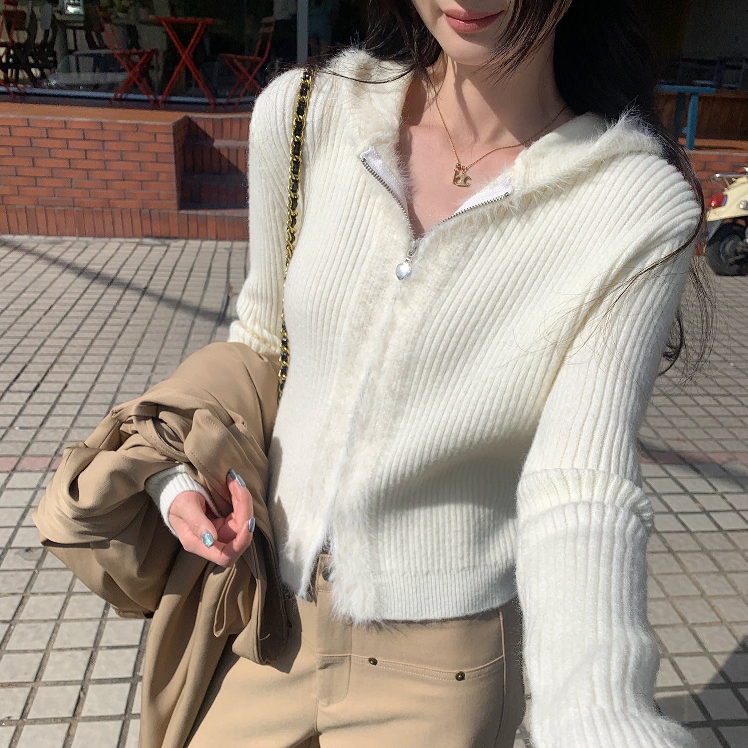 Woman wearing Hooded Knit Cardigan with Fur Collar in a cozy setting