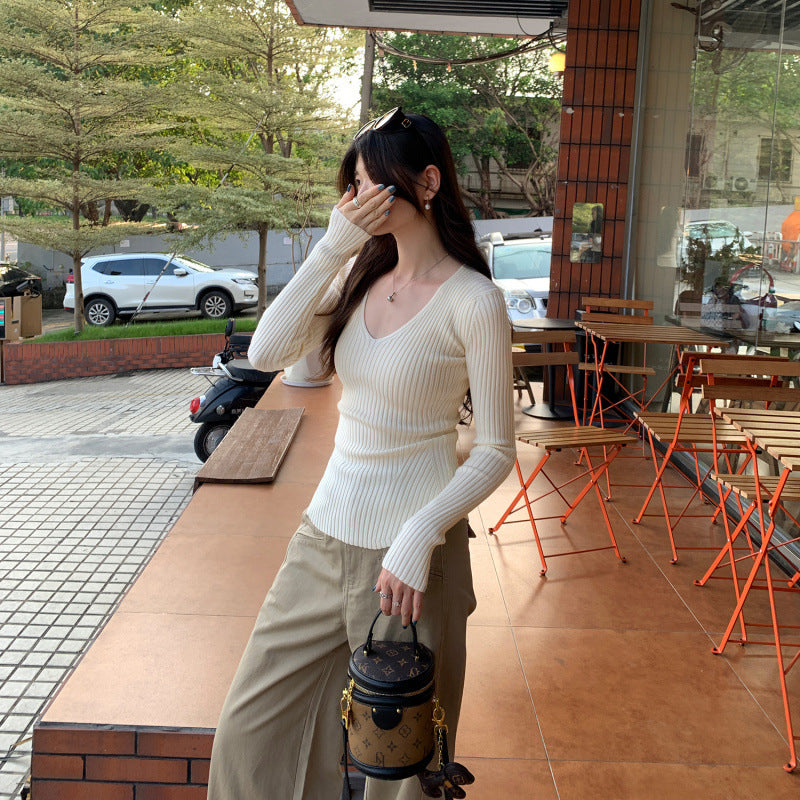 Woman wearing V-Neck Ribbed Knit Top in a stylish urban setting