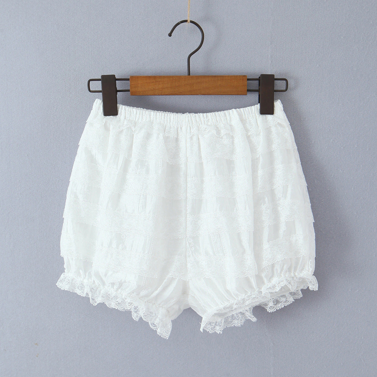 Woman wearing Baby Collar Pleated Top and Cake Layer Shorts Set in a sunny outdoor setting
