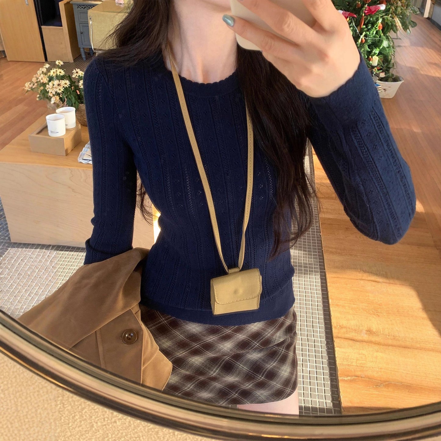 Woman wearing Hollow-Out Round Neck Long Sleeve Knit Top in a stylish setting