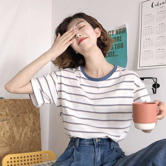 Woman wearing Academy Style Loose Fit Striped T-Shirt in a casual setting