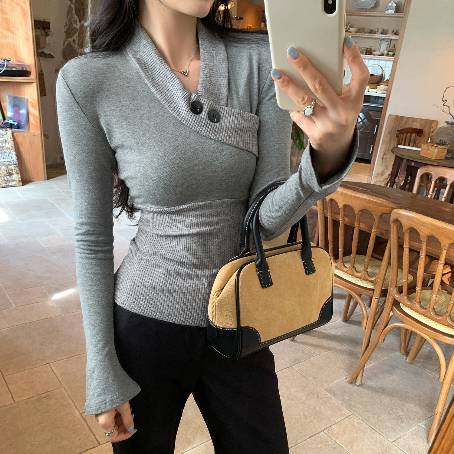 Woman wearing Elegant V-Neck Button Detail Knit Top in a stylish setting