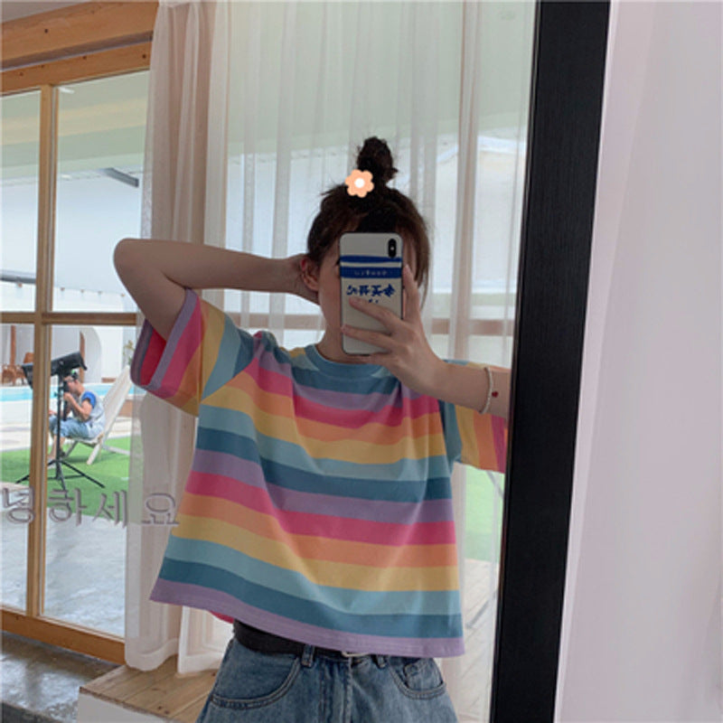 Woman wearing Rainbow Stripe Loose T Shirt in a sunny outdoor setting