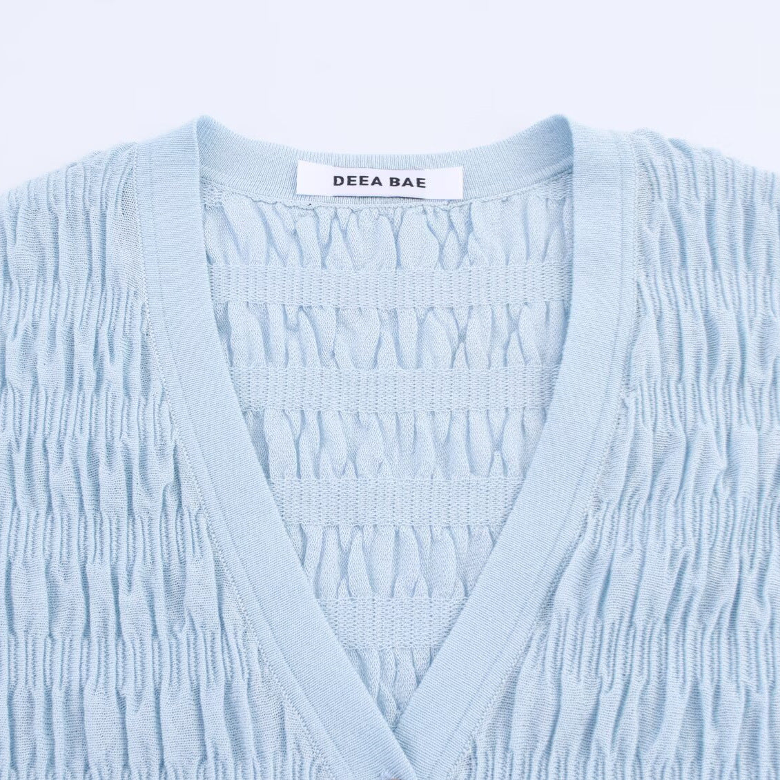 Woman wearing Light Blue Pleated Knitted Jacket in a casual setting