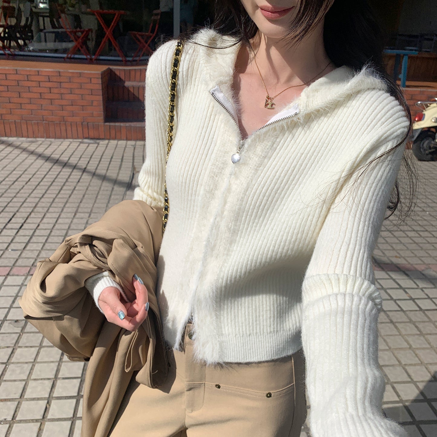 Woman wearing Hooded Knit Cardigan with Fur Collar in a cozy setting