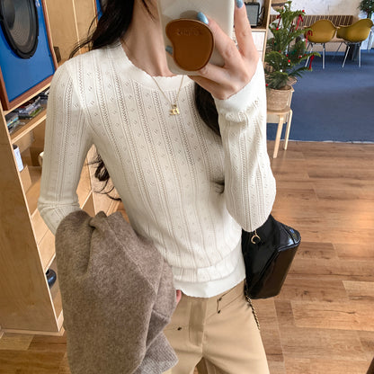Woman wearing Hollow-Out Round Neck Long Sleeve Knit Top in a stylish setting
