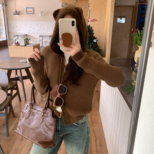 Woman wearing Hooded Knit Cardigan with Fur Collar in a cozy setting
