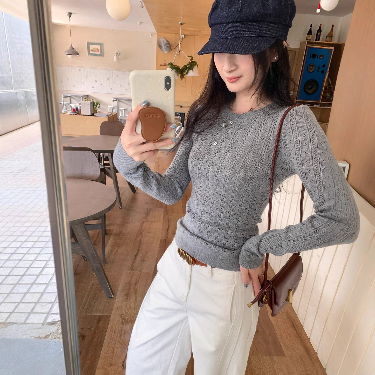 Woman wearing Hollow-Out Round Neck Long Sleeve Knit Top in a stylish setting