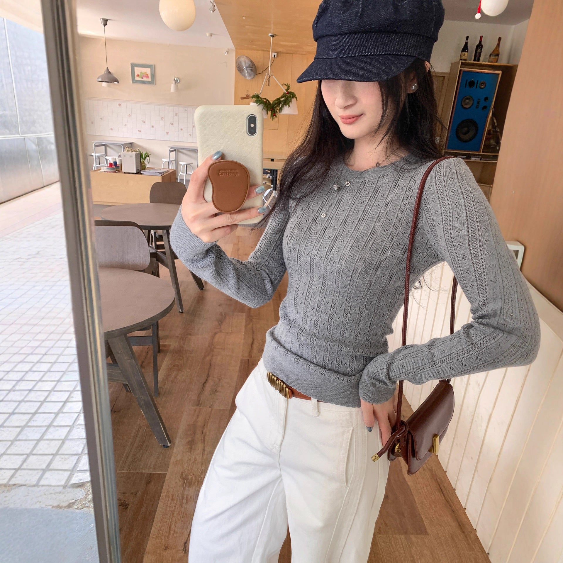 Woman wearing Hollow-Out Round Neck Long Sleeve Knit Top in a stylish setting