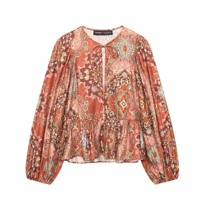 Woman wearing Retro Printed Long Sleeve Top with Skirt Hem in a bright cafe setting