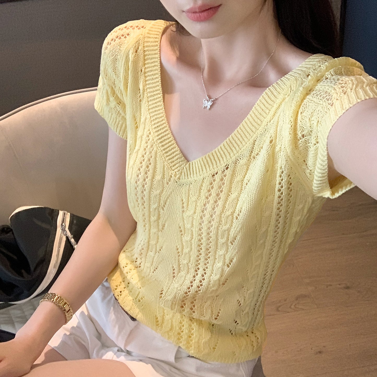 Woman wearing V-Neck Hollow Knit Top in a stylish outdoor setting