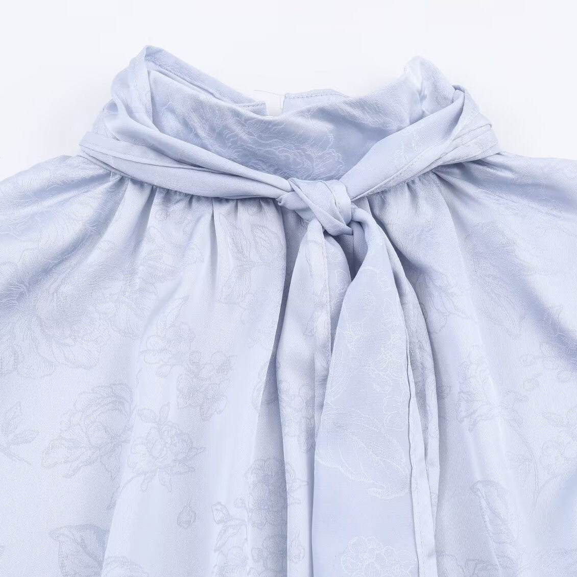 Woman wearing Embroidered Satin Bow Detail Blouse in a chic setting