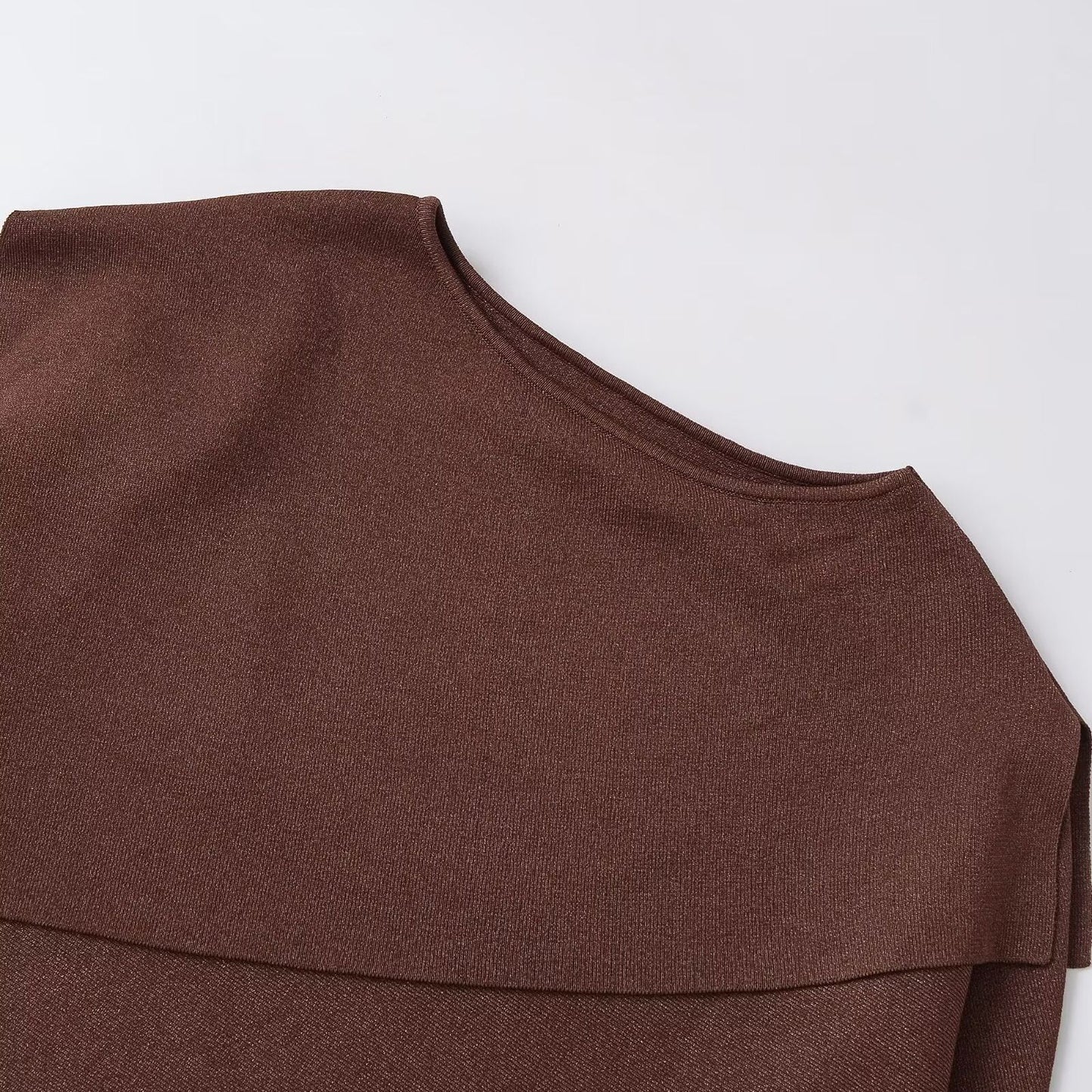 Woman wearing Loose Metallic Thread Knitted Cape Pullover in a cozy setting