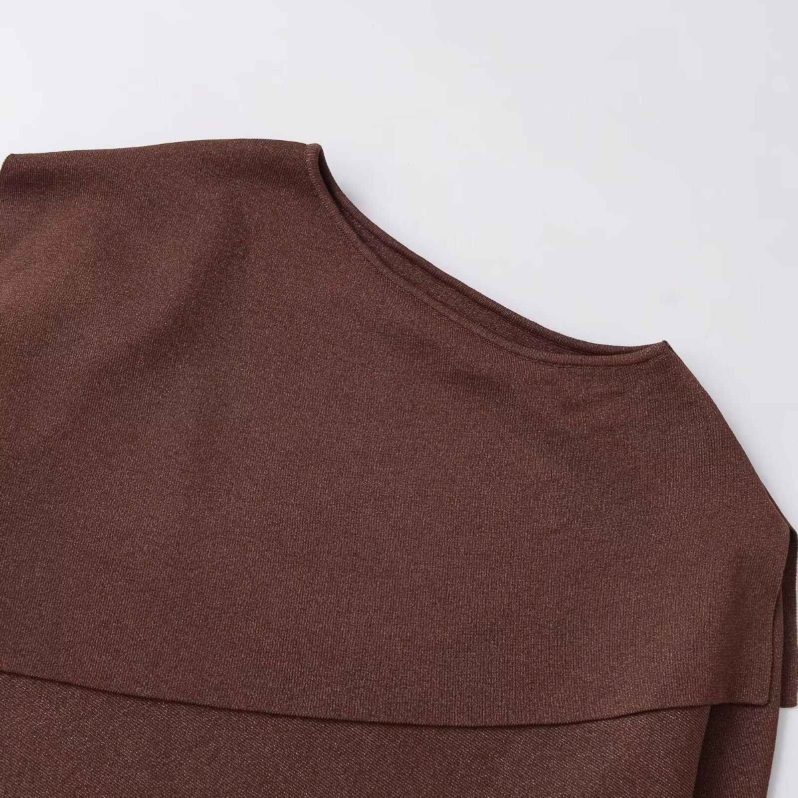 Woman wearing Loose Metallic Thread Knitted Cape Pullover in a cozy setting