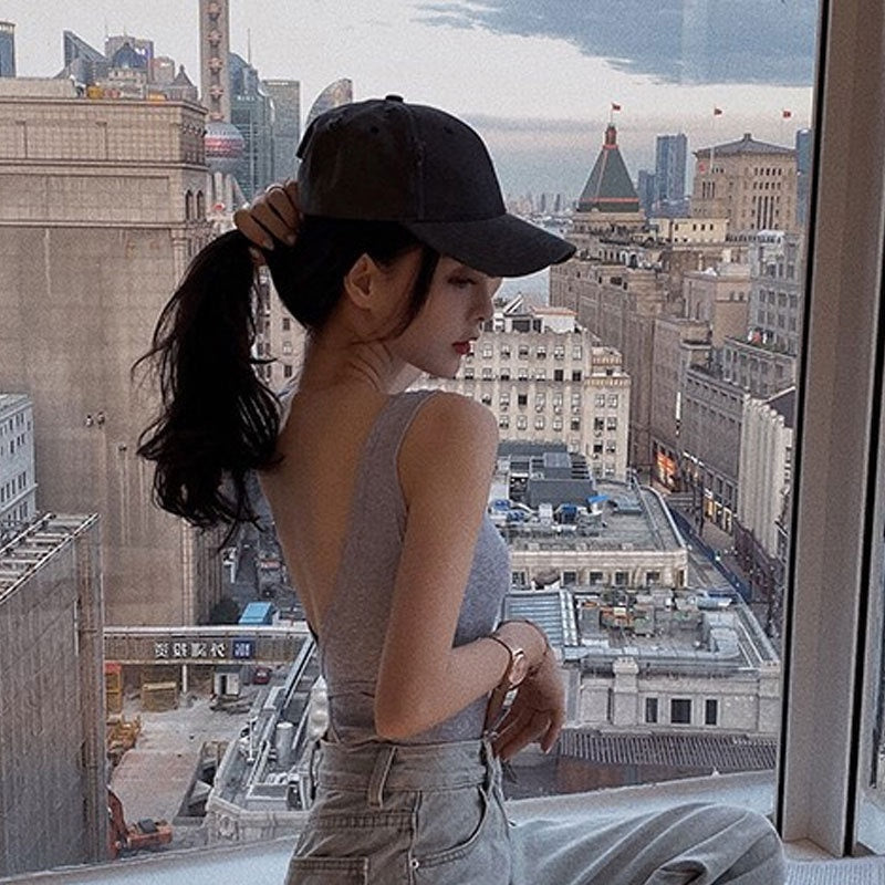 Woman wearing Cross Backless Camisole in a sunny outdoor setting