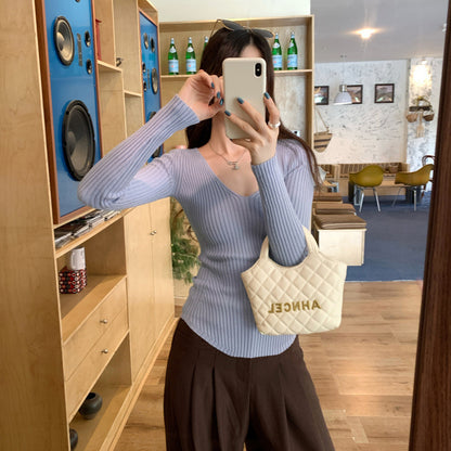 Woman wearing V-Neck Ribbed Knit Top in a stylish urban setting